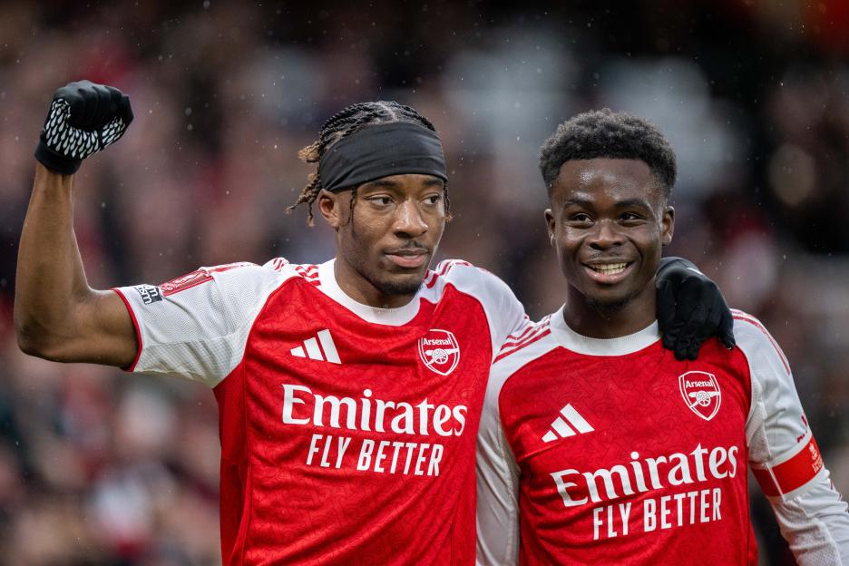 Noni Madueke celebrates with Bukayo Saka after scoring a goal.