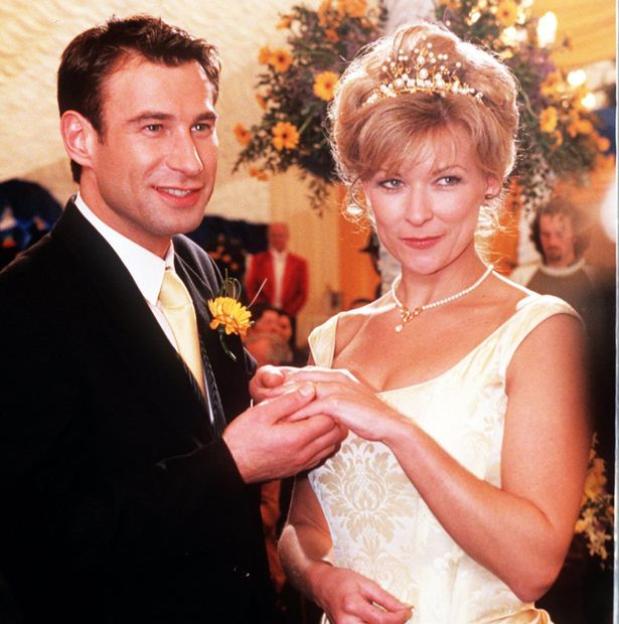 A man placing a ring on a woman's finger at a wedding.