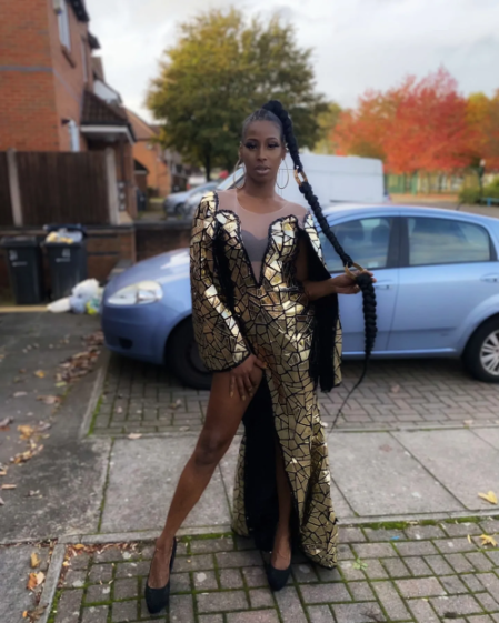 Sherrell Dillion posing in a shimmering gold and black dress.
