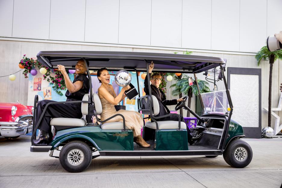 Johannes Radebe, Emma Willis, and Josh Widdicombe in a golf cart.