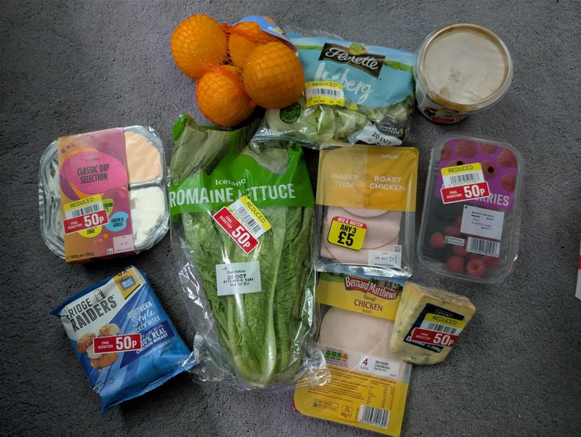 Grocery haul with several reduced-price items including romaine lettuce, iceberg lettuce, oranges, raspberries, wafer-thin roast chicken, Bernard Matthews roast chicken slices, blue cheese, classic dip selection, and fridge raiders.
