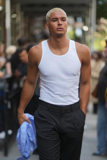 Marlon Lundgren Garcia in a white tank top, black pants, and a blue shirt at New York Fashion Week.