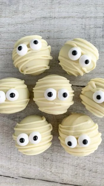 Halloween Mummy Oreo Truffles on a light wooden background.