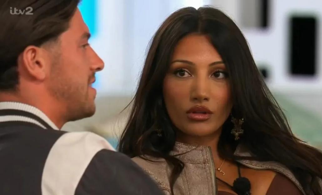 Woman with dark hair and tan skin looking intently at a man.