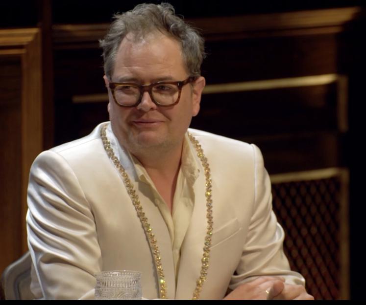 Alan Carr smiling at the Celebrity Traitors Final Round Table.
