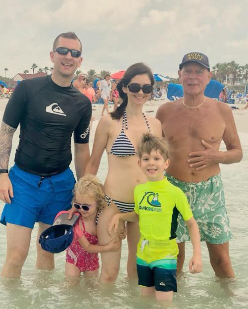 Family photo of Richard James, Emma James, Monika Rubacha, Josh James, and Peter James at the beach.