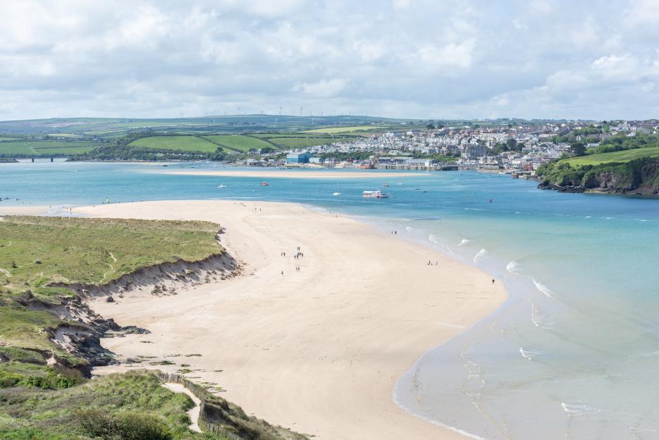 a large body of water with a sandy beach in the foreground