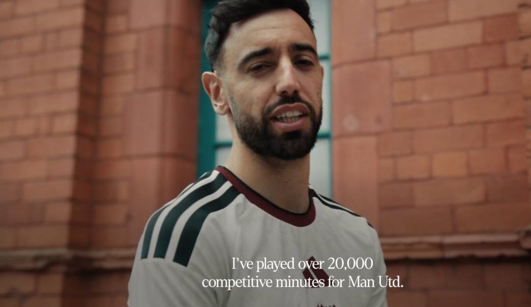 A man with a beard, wearing a white and green striped shirt, speaks in a video with the caption, "I've played over 20,000 competitive minutes for Man Utd."