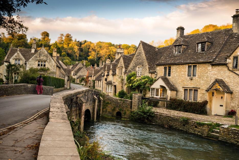 A peaceful scene of a mother and child in the light of the days' end in Castle Combe, a pretty village in the Cotswolds, England.