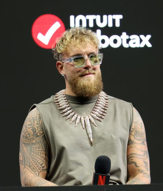 Jake Paul during a press conference with a Netflix microphone in the foreground.