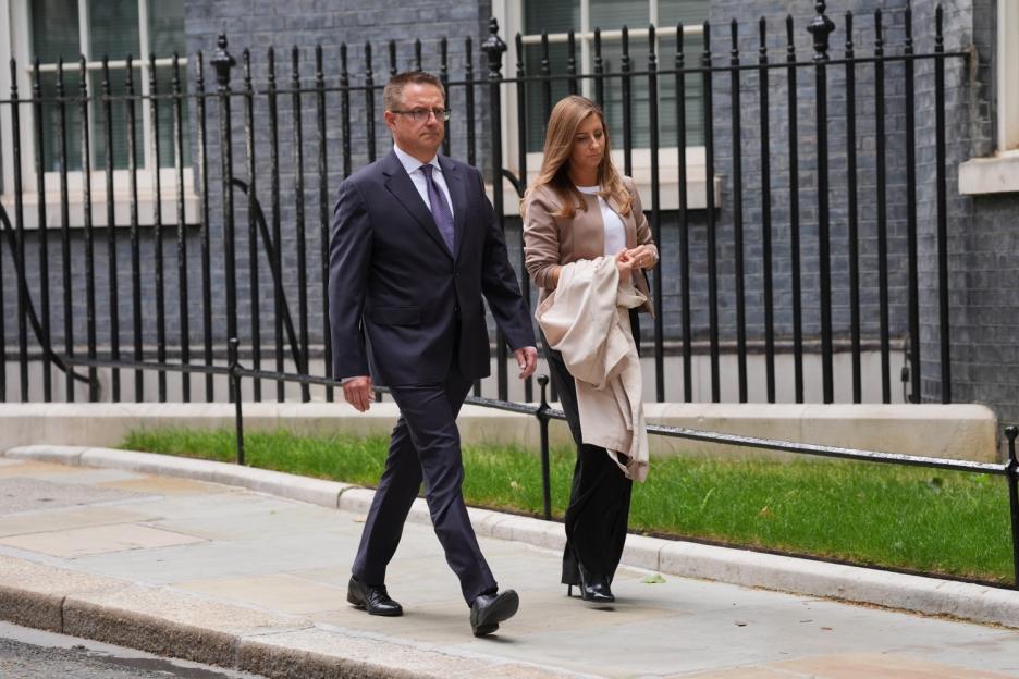 Henry Nowak walks with a woman next to a fence.