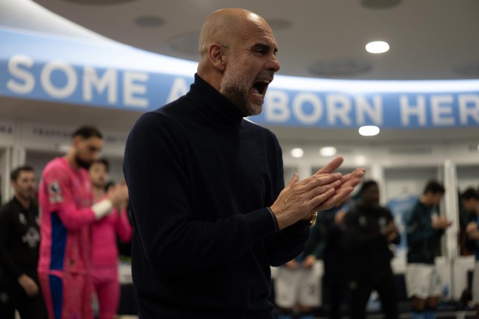 Pep Guardiola applauding in the dressing room after a Premier League match.