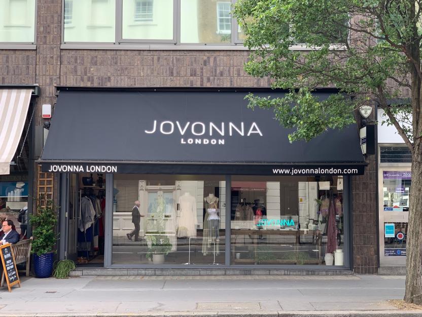 The storefront of Jovonna London with a black awning and displays visible through the windows.