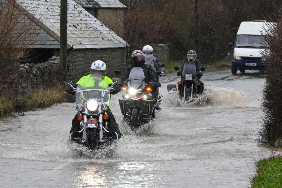 Motorcyclists ride through flooding on the B3157 Jurassic Coast Road in Bridport, Dorset, during heavy rain.