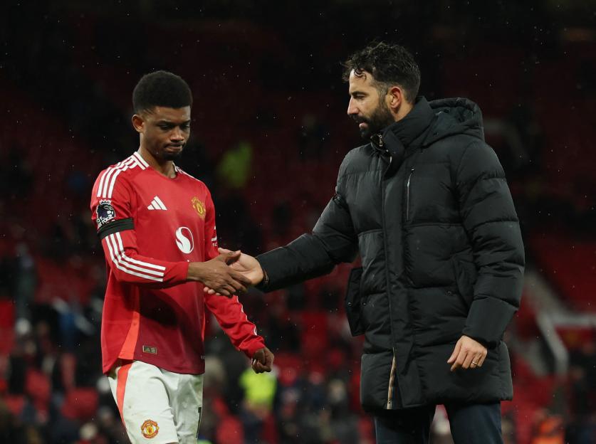 Manchester United's Amad Diallo shaking hands with manager after a match.