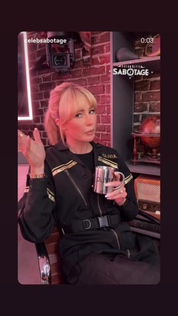 Olivia Attwood in a black jumpsuit holding a metal mug that reads "Olivia."