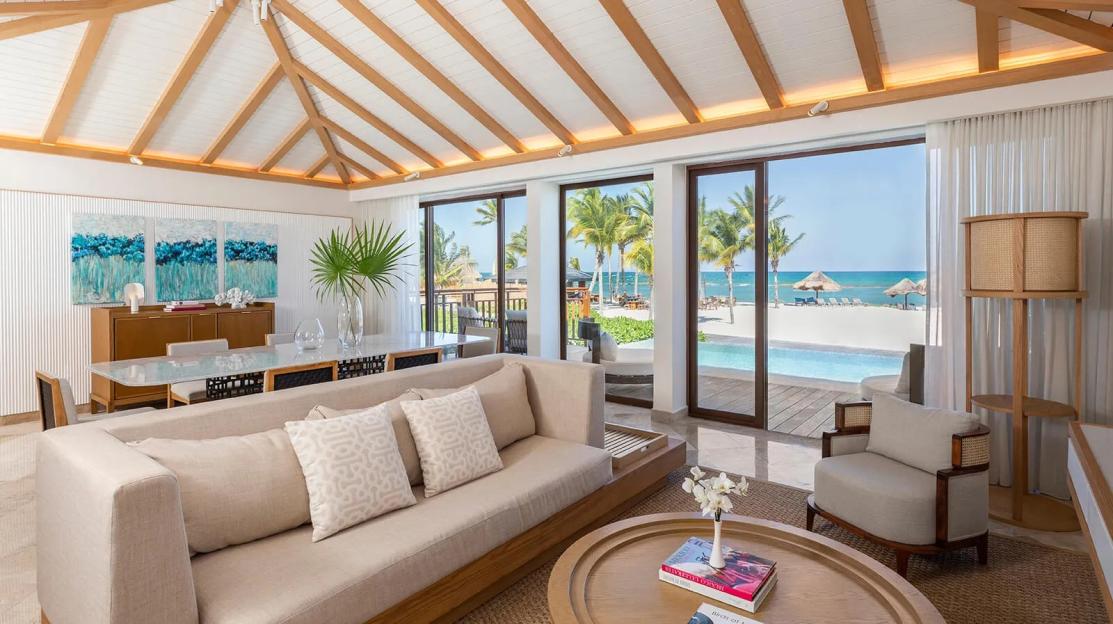 Living room of the Award-Winning Luxury Hotel Riviera Maya - Fairmount Mayakoba with views of the ocean, beach, and palm trees.
