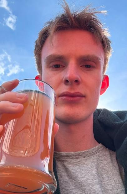 Actor Jake Parry holding a drink.