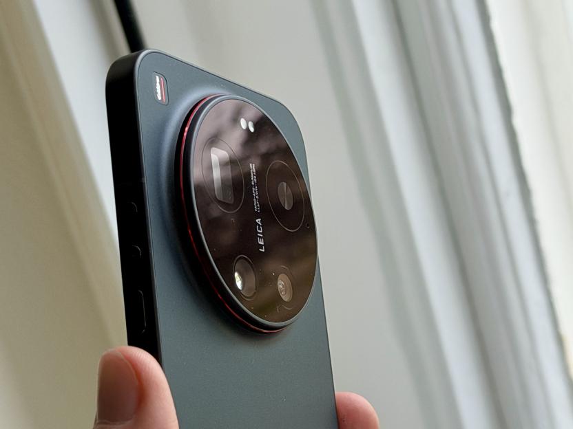 Hand holding a black Xiaomi 13 Ultra phone with a prominent circular camera bump.