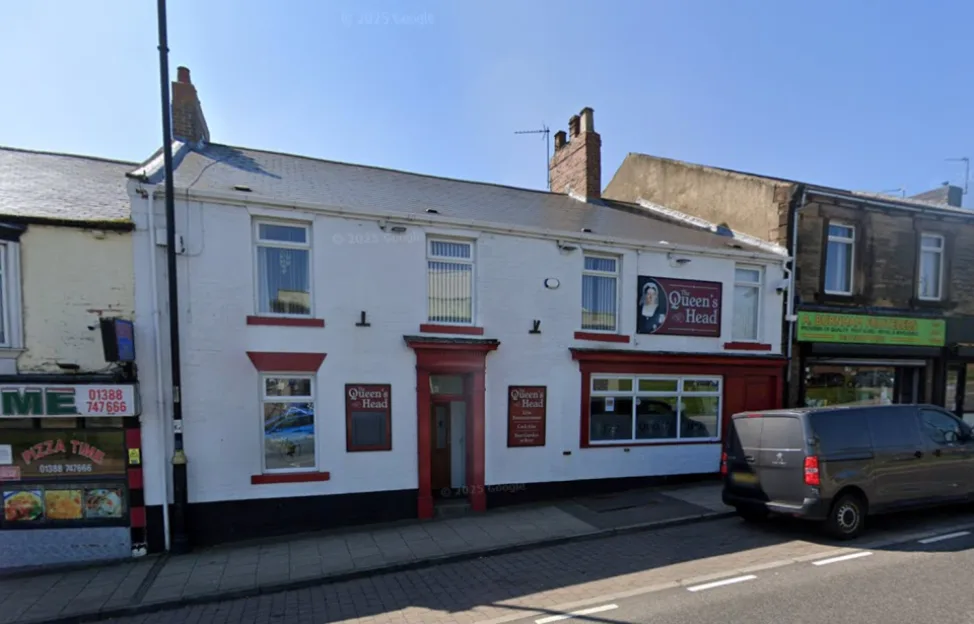 Exterior view of The Queen's Head pub with a white facade and red trim on a high street.