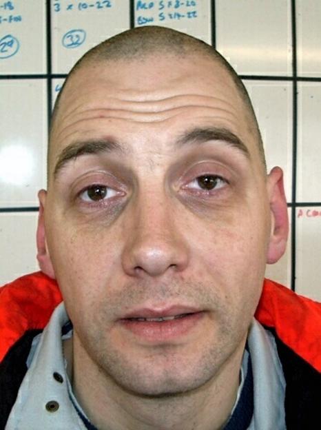 Mugshot of Peter Voisey, 54, with a shaved head and wearing a light blue and red jacket.