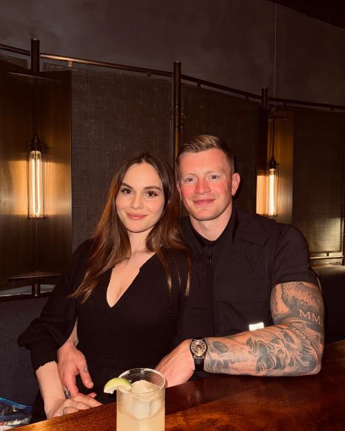 Holly Ramsay and Adam Peatty sitting together at a table.