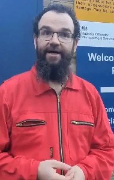 A man in a red jumpsuit standing outside HMP Pentonville.