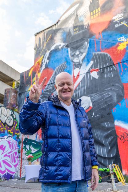 Jake Wood in front of a giant mural of Sir Winston Churchill at his debut art exhibition.