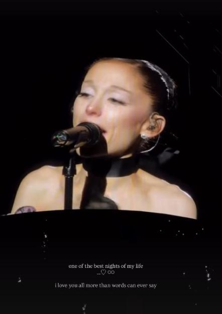 Ariana Grande crying and singing into a microphone onstage.