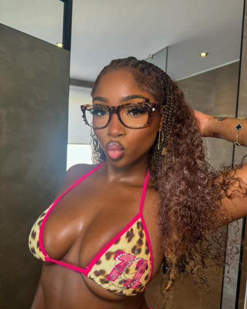 Indiyah Polack in a leopard print bikini top and glasses, puckering her lips.