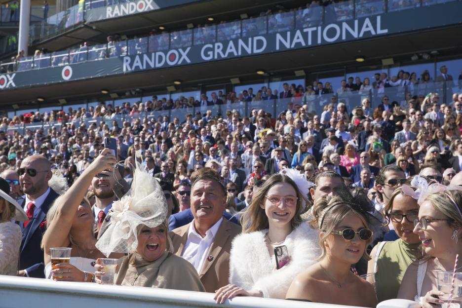 Spectators watch the first race at the Grand National Horse Racing meeting.