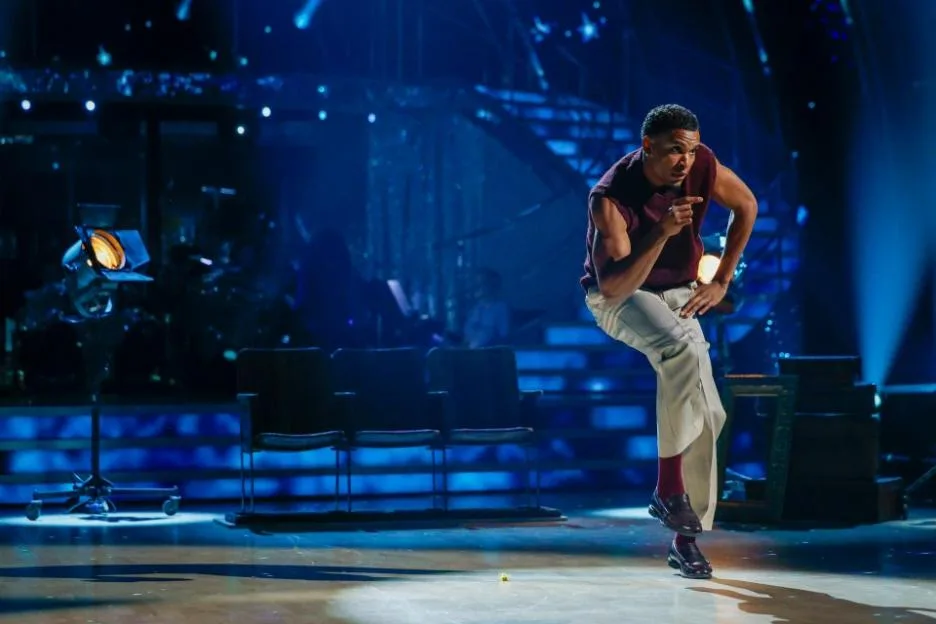 Cach Mercer dancing on stage under blue lights.
