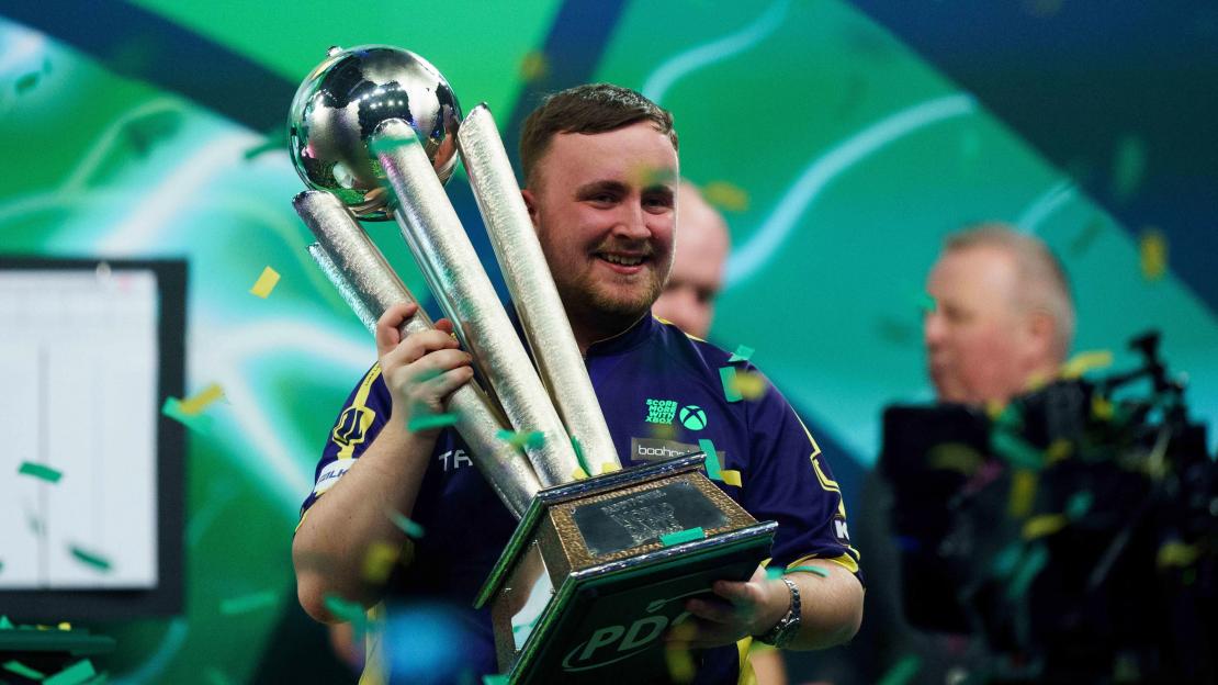 Luke Littler lifting the Paddy Power World Darts Championship trophy.
