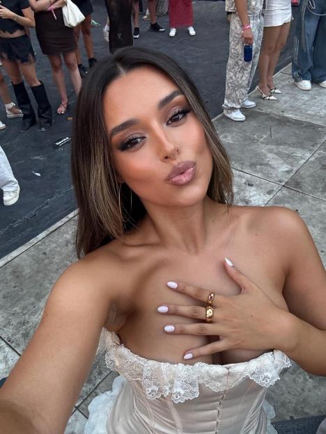 Marta Diaz in a strapless top and rings poses for a selfie.