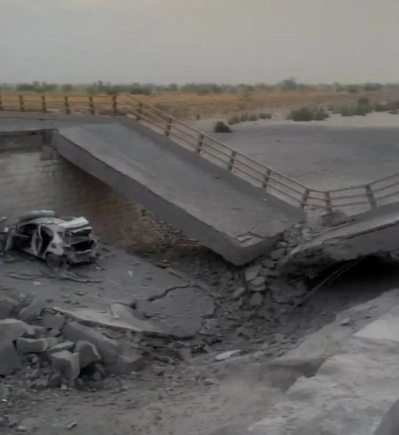 A damaged portion of a bridge in the aftermath of a strike, in Bandar Khamir