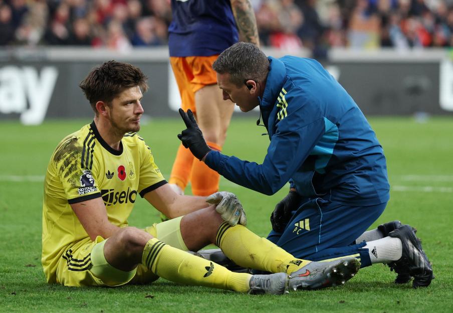 Newcastle United's Nick Pope receiving medical attention for an injury.