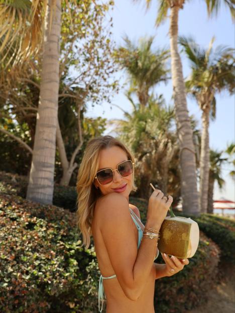Amanda Holden in a bikini, drinking from a coconut on a luxury holiday.