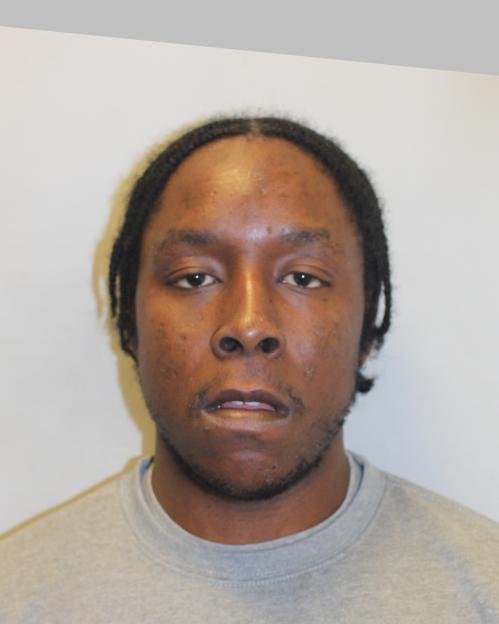 Headshot of Joshua Jacques, a Black man with braided hair, a mustache, and a short beard, wearing a grey crew-neck sweatshirt.