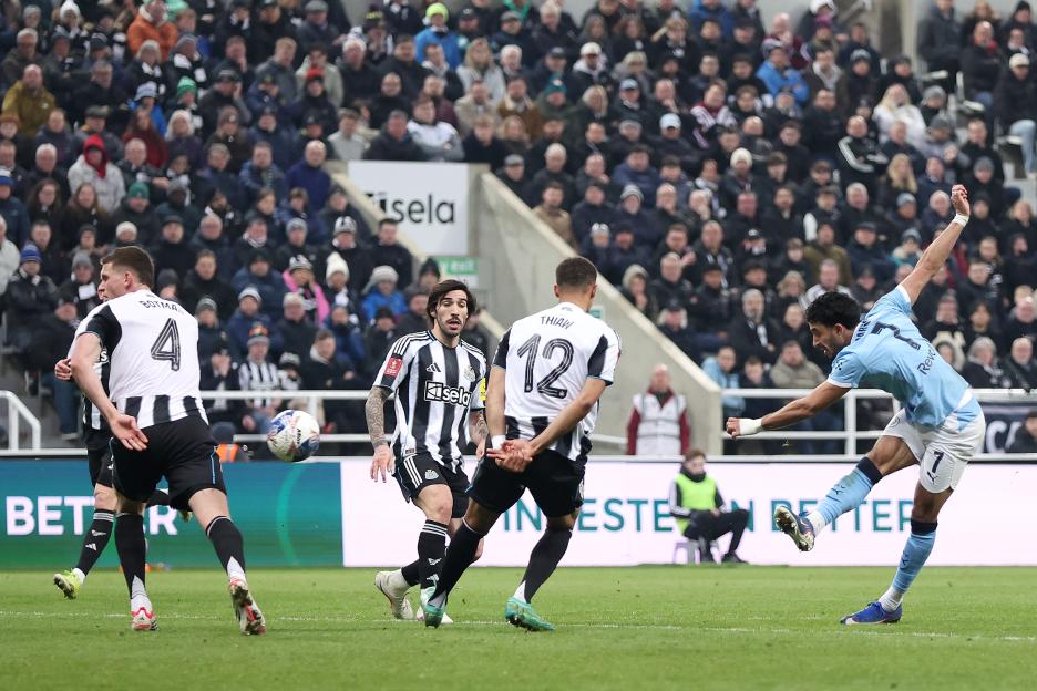 Omar Marmoush of Manchester City kicking the ball towards the goal during a soccer match.