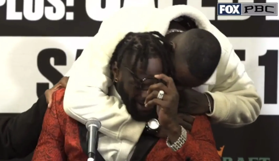 Deontay Wilder crying at a press conference as Malik Scott hugs him.