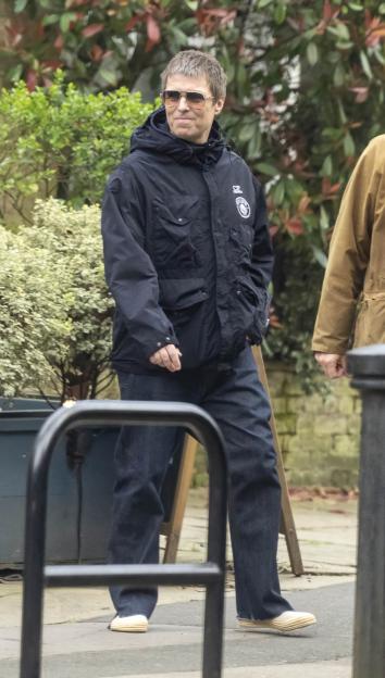 Liam Gallagher wearing sunglasses, a black jacket, and dark jeans.