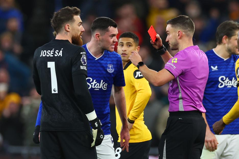 Referee Thomas Kirk shows a red card to Everton's Michael Keane.