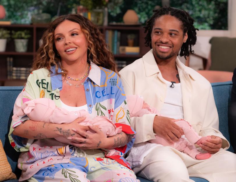 Jesy Nelson and Zion Foster holding their baby girls, Ocean Jade and Story Monroe, on television.