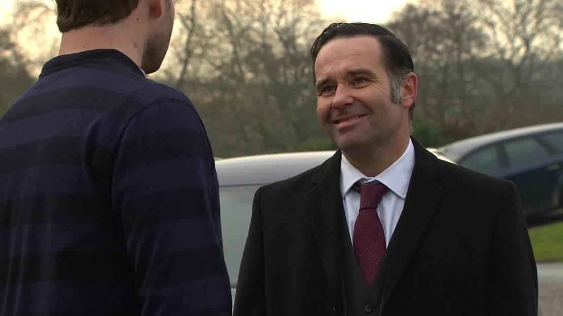 Andrew Scarborough as Graham Foster smiling at Alexander Lincoln as Jamie Tate.