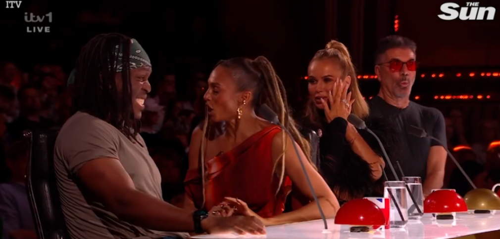 Four judges reacting to a performance, one smiling, two looking surprised, and one making a funny face.
