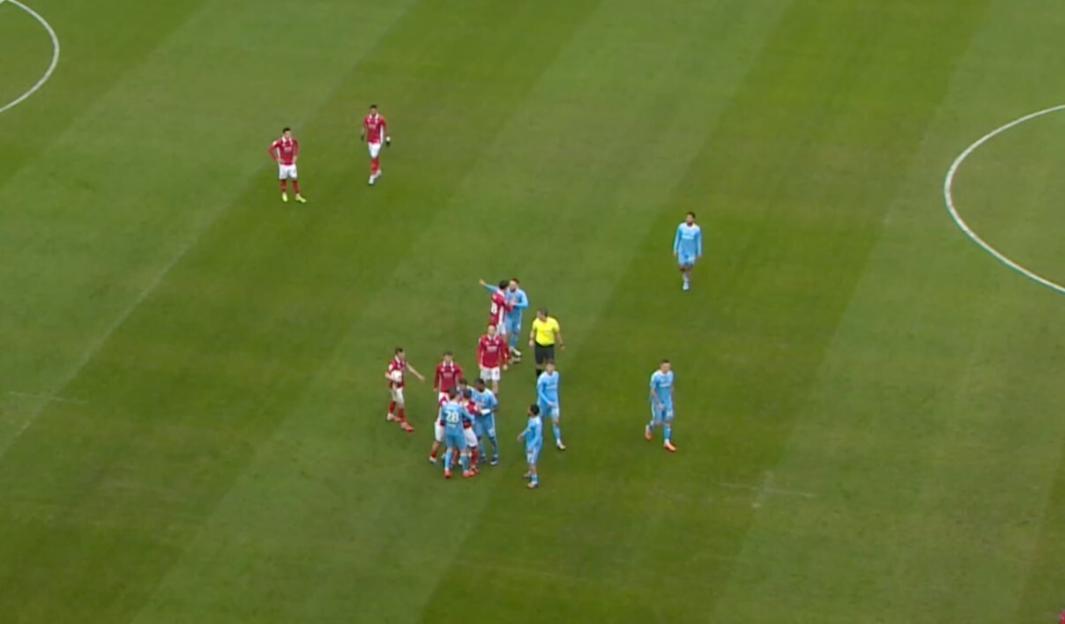 Soccer players and a referee on a green field.