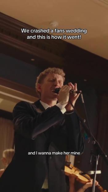 Nathan Evans singing into a microphone at a wedding.
