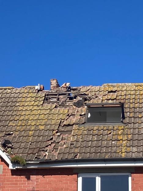Damaged roof of Tara Craven's home with a large hole and broken tiles.