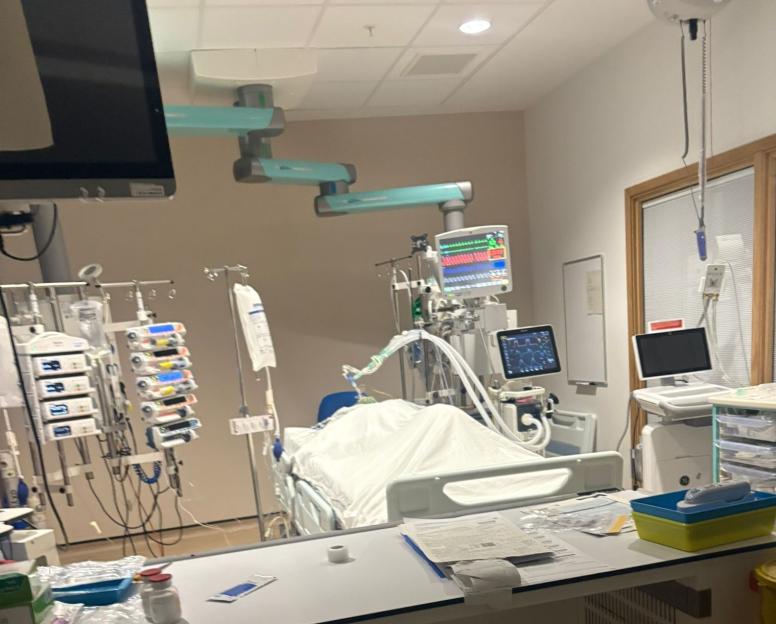 A hospital room with a bed, medical equipment, and monitors.