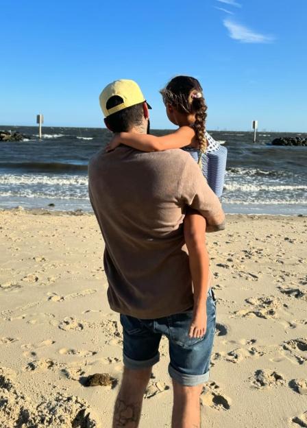 Zayn Malik holding his daughter on a beach.